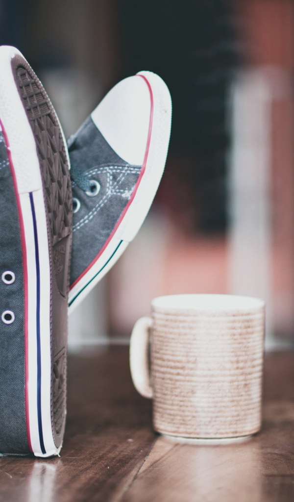 Кеды и чашка на столе