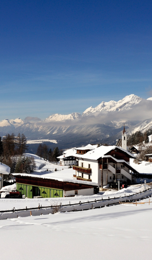 Дома на фоне гор на курорте Зеефельд, Австрия