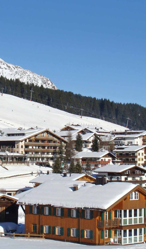 Дома на фоне гор на горнолыжном курорте Лех, Австрия