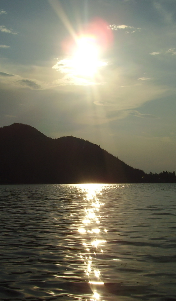 Солнце над водой озера Клопайнер Зее, Австрия