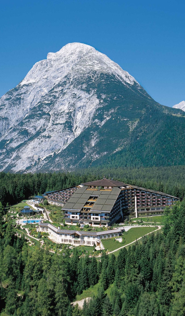 Отель на фоне горы на курорте Тельфс-Бюхен, Австрия