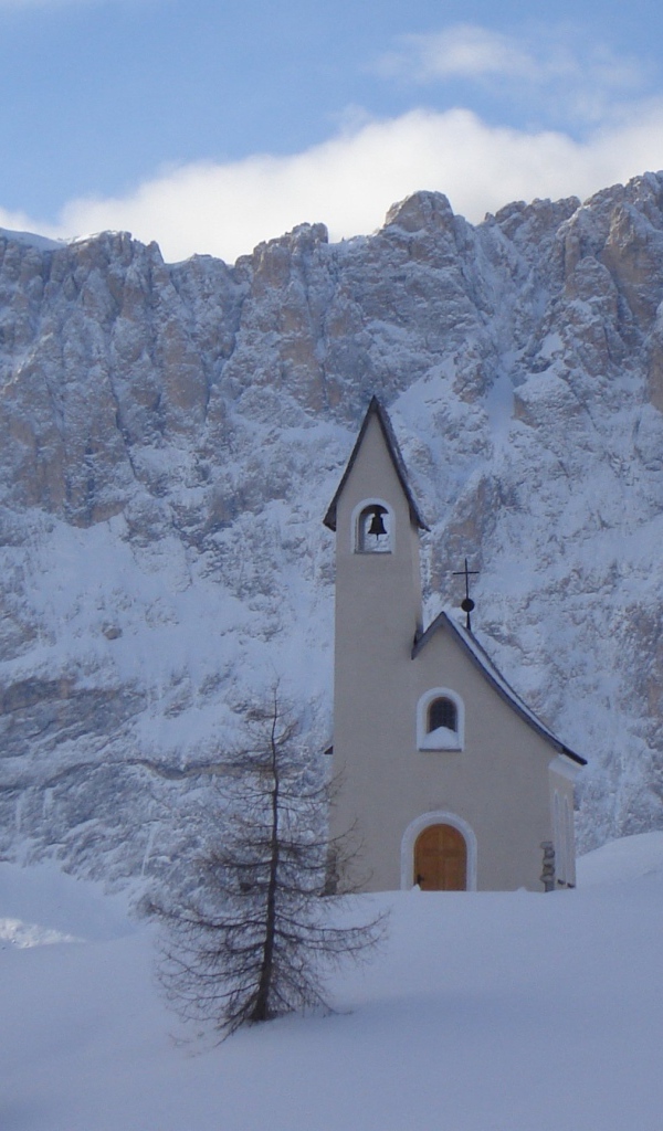Церковь на фоне Альп на горнолыжном курорте Валь Гардена, Италия