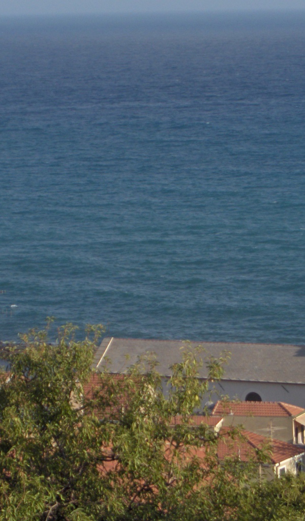 Башня с часами на фоне моря в Санто Стефано аль Маре, Италия