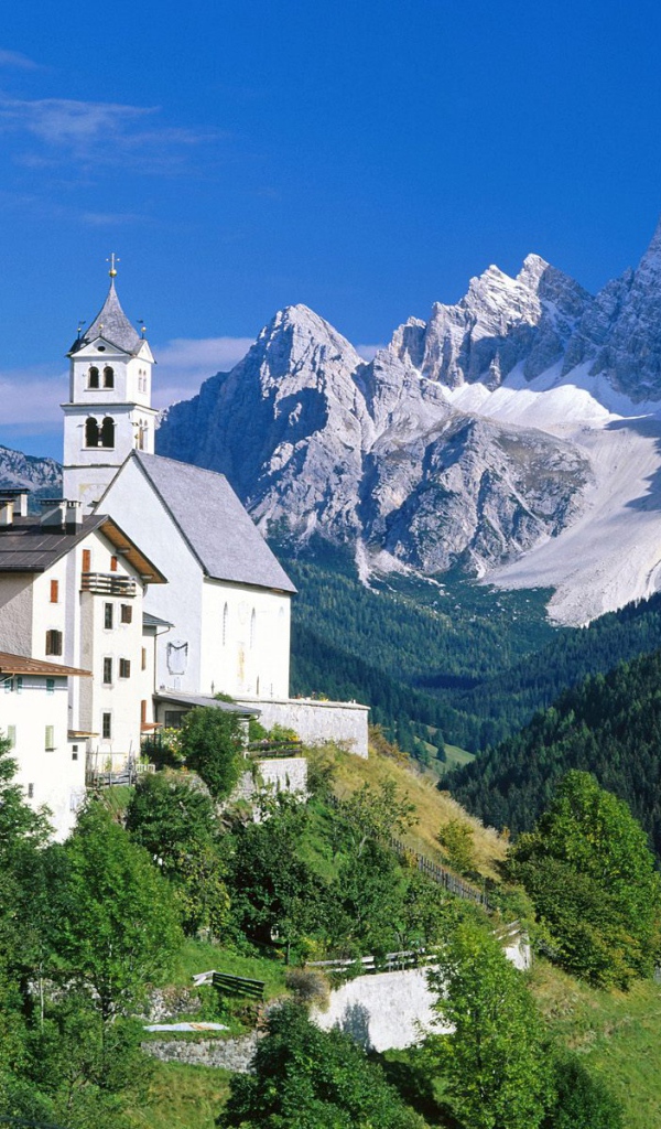 Дома на фоне гор на горнолыжном курорте Кортина д'Ампеццо, Италия