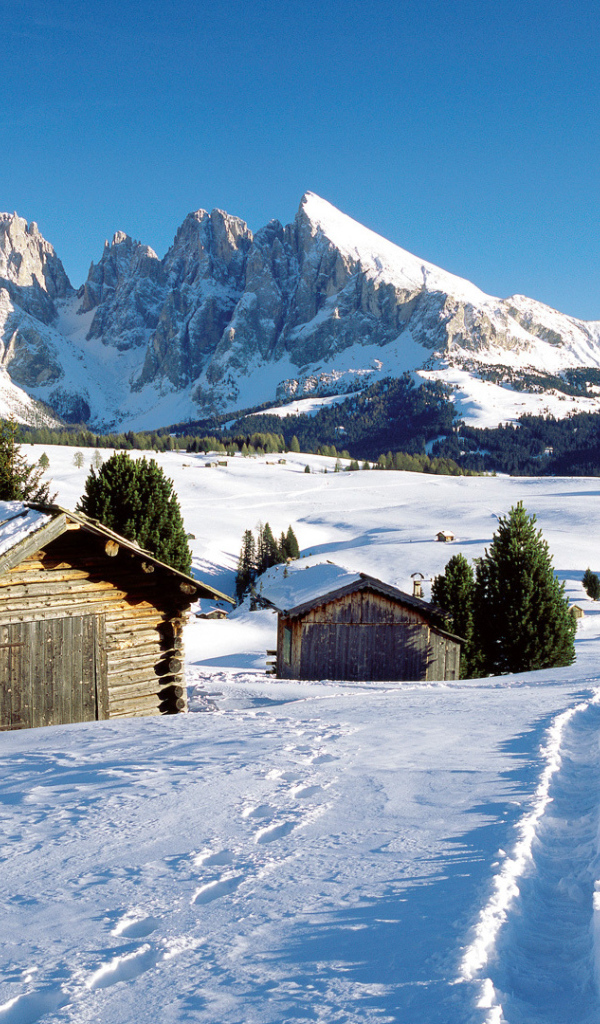 Дома на фоне гор на горнолыжном курорте Валь Гардена, Италия