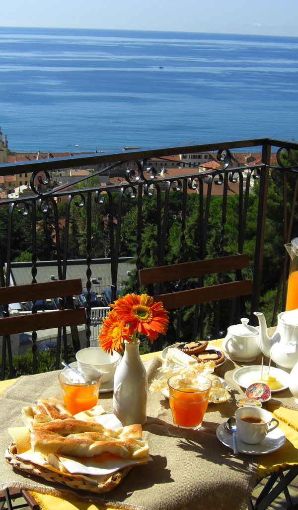 Отдых в кафе на террассе на курорте в Пьетра Лигуре, Италия