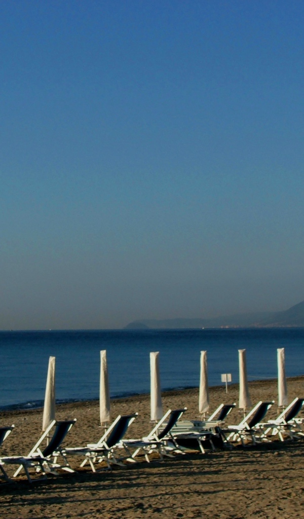 Лежаки на пляже на курорте Финале Лигуре, Италия