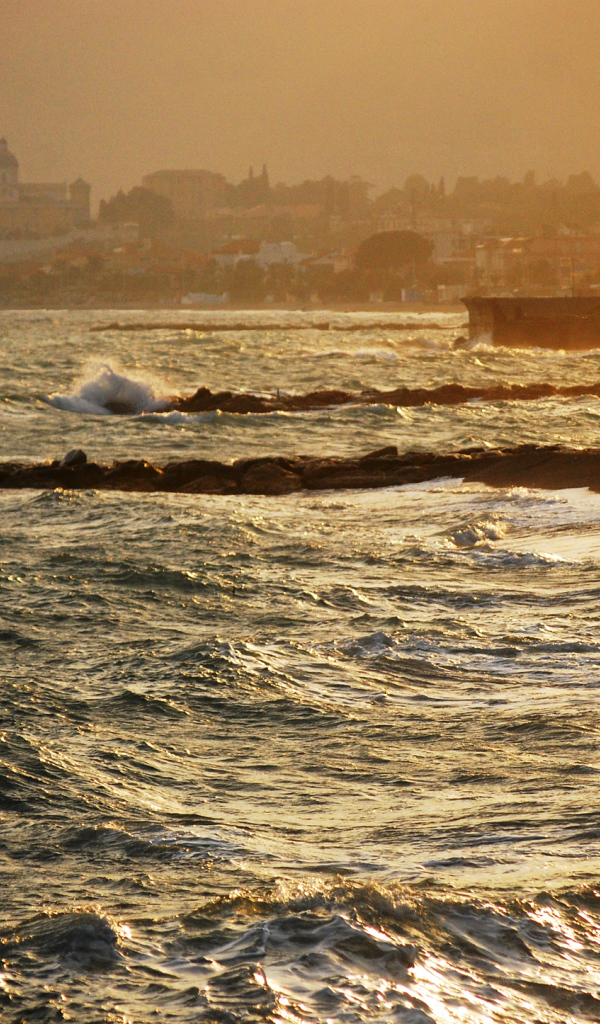 Закат на пляже на курорте в Пьетра Лигуре, Италия