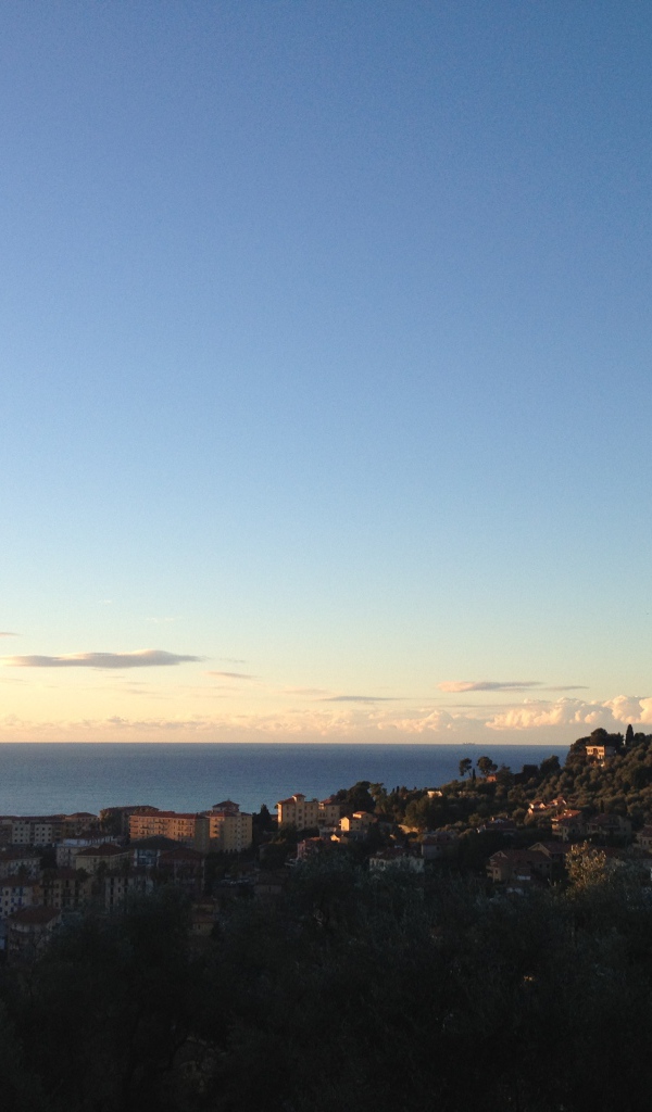 Закат над городом на курорте Империя, Италия