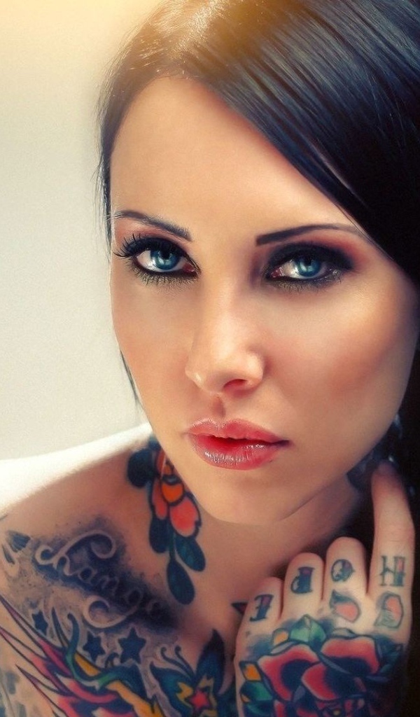 Голубоглазая девушка с татуировкой на руке и плече