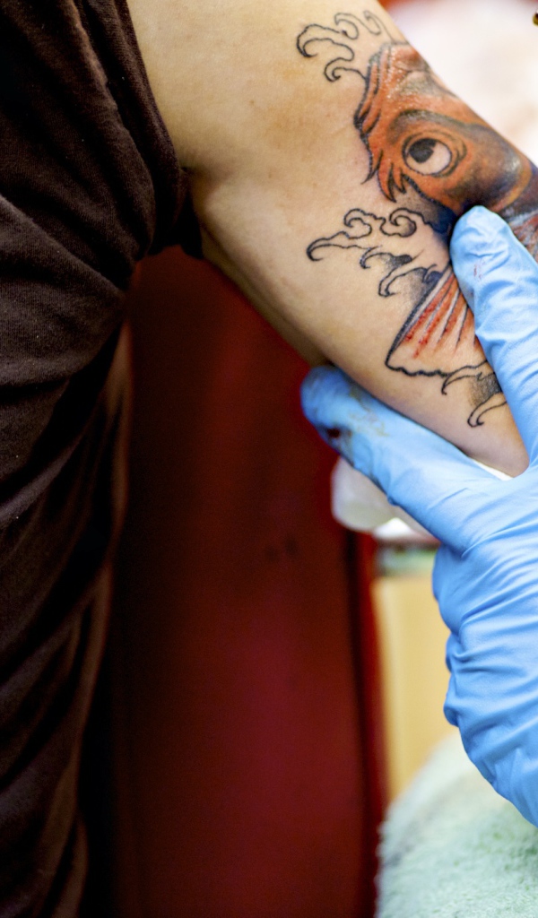 Девушке делают татуировку