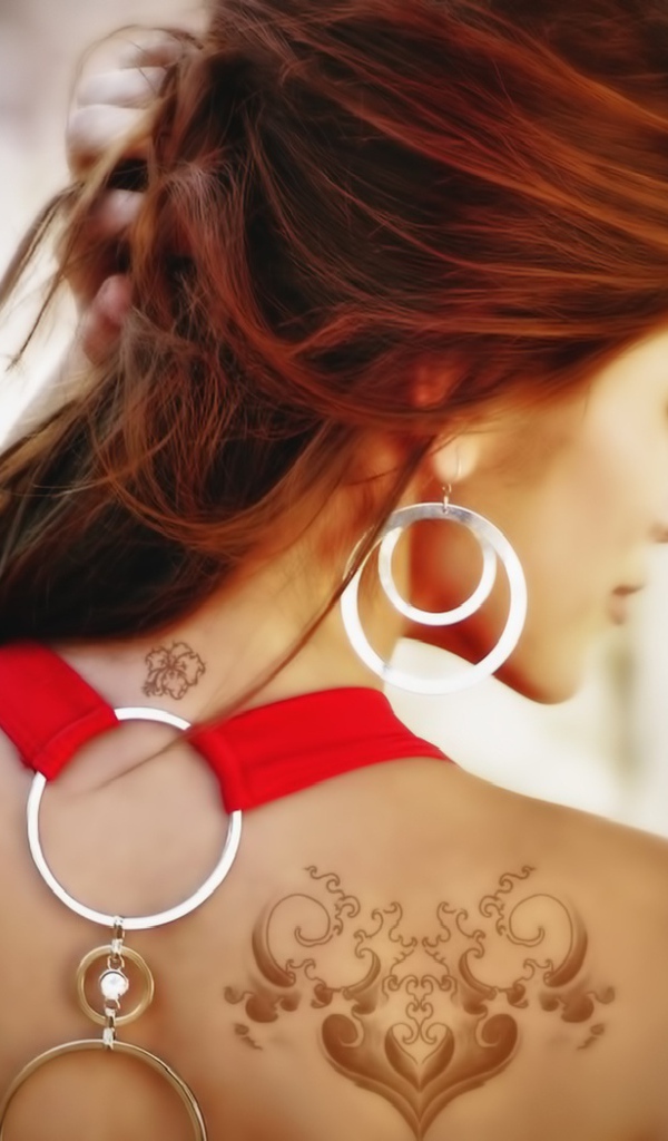 Девушка с татуировками на плече и шее