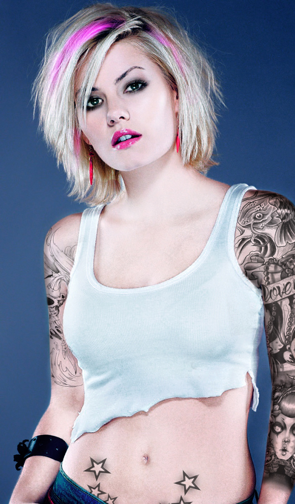 Девушка бунтарка с татуировками на руке и животе