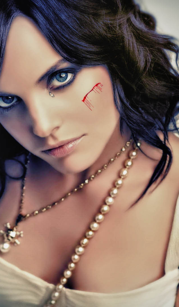 Шрам на щеке и татуировка на плече у девушки