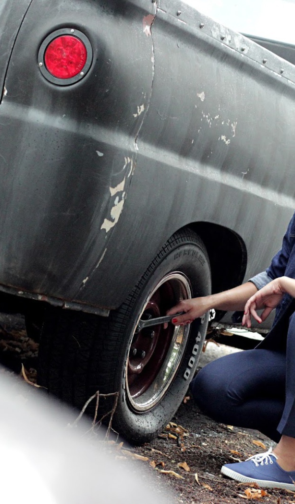 Девушка чинит автомобиль