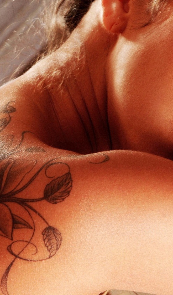 Татуировка на спине у брюнетки