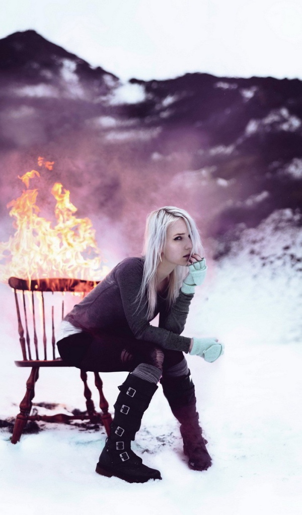 Девушка сидит на горящем стуле