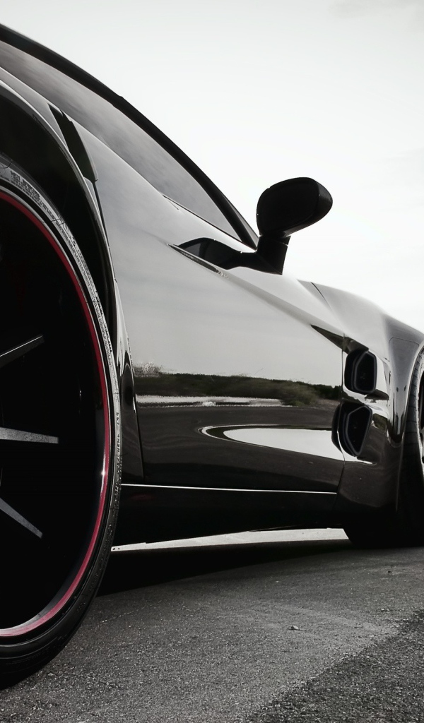 Черный автомобиль перед дорожными знаками