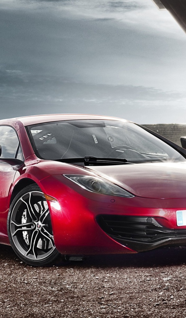 Красный McLaren на коричневом гравии