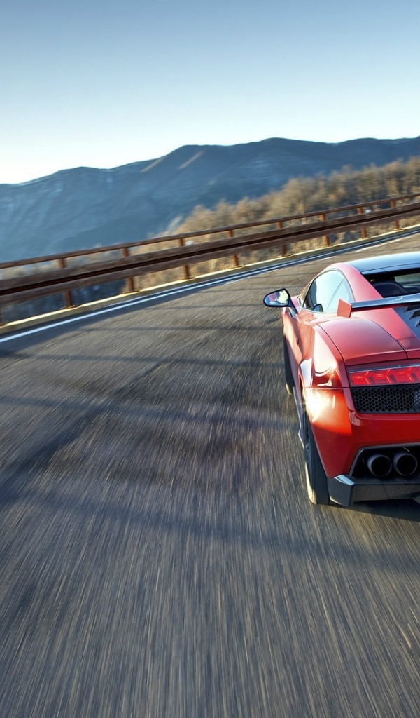 Красный гоночный автомобиль на горной дороге