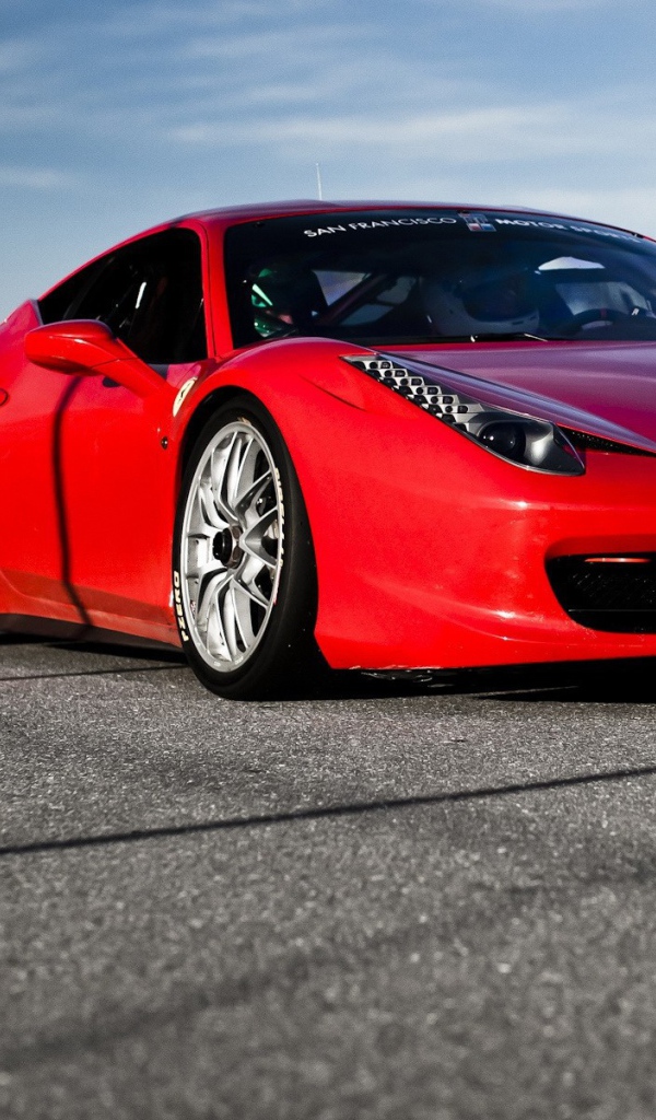 Красный спортивный автомобиль на гладком сером асфальте