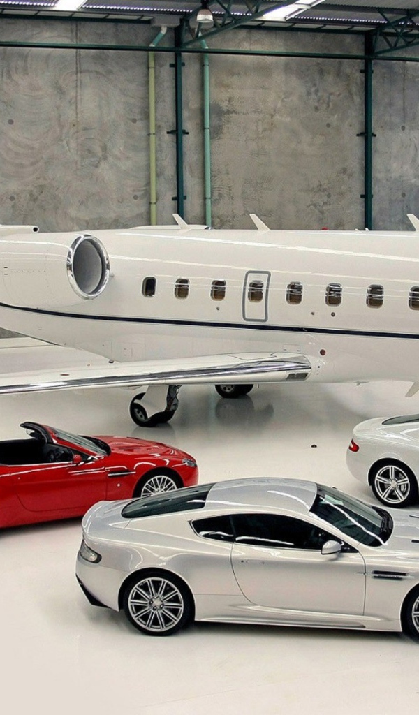 Автомобили Aston Martin в ангаре у частного самолета