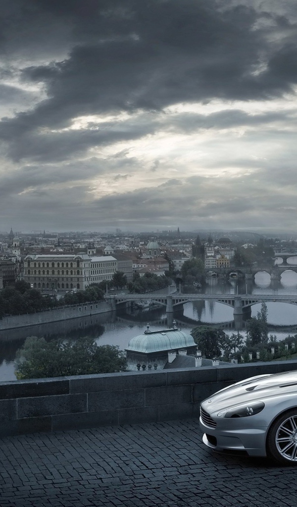 Серый Aston Martin на фоне города