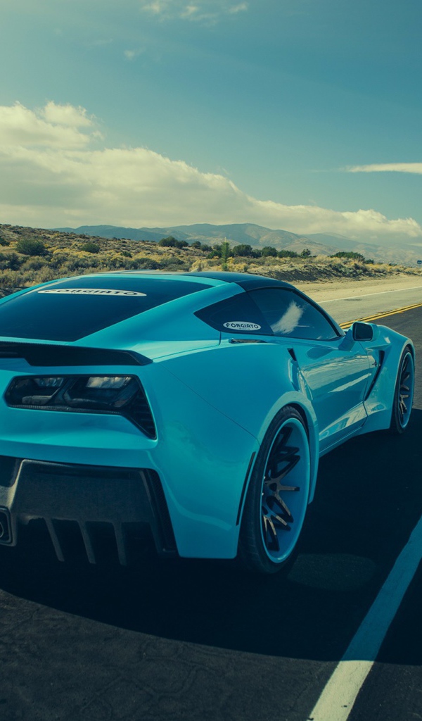 Голубой спортивный Chevrolet на шоссе в жаркой пустыне