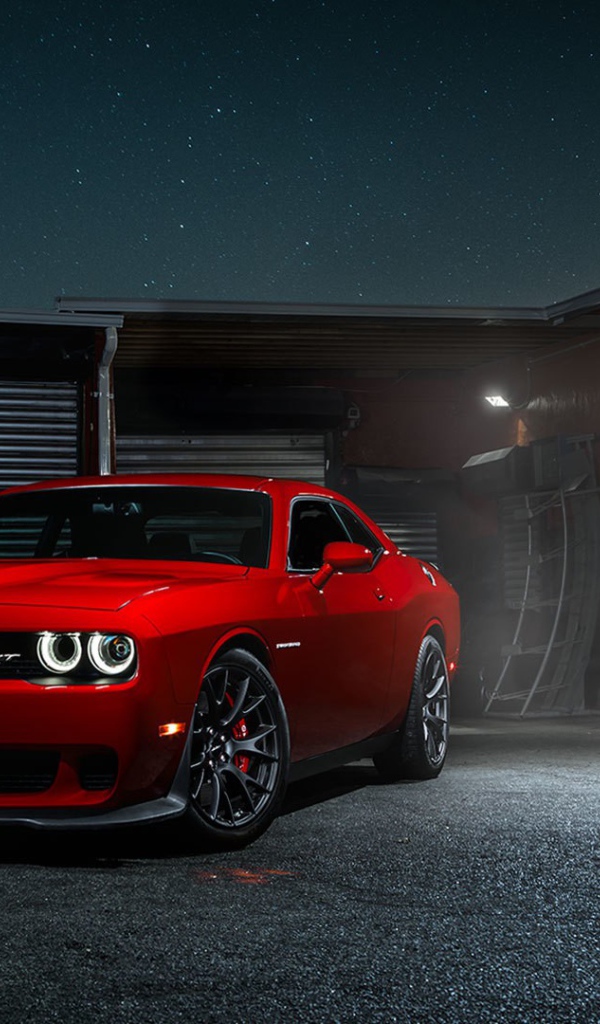 Красный Dodge Challenger Hellcat у гаража
