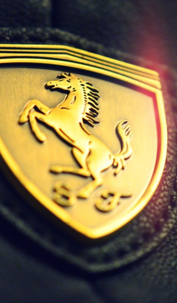 Золотой символ Ferrari на черной коже