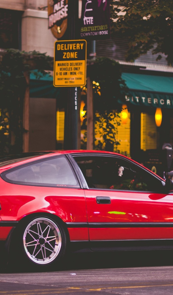 Red Honda CRX is standing at a street cafe