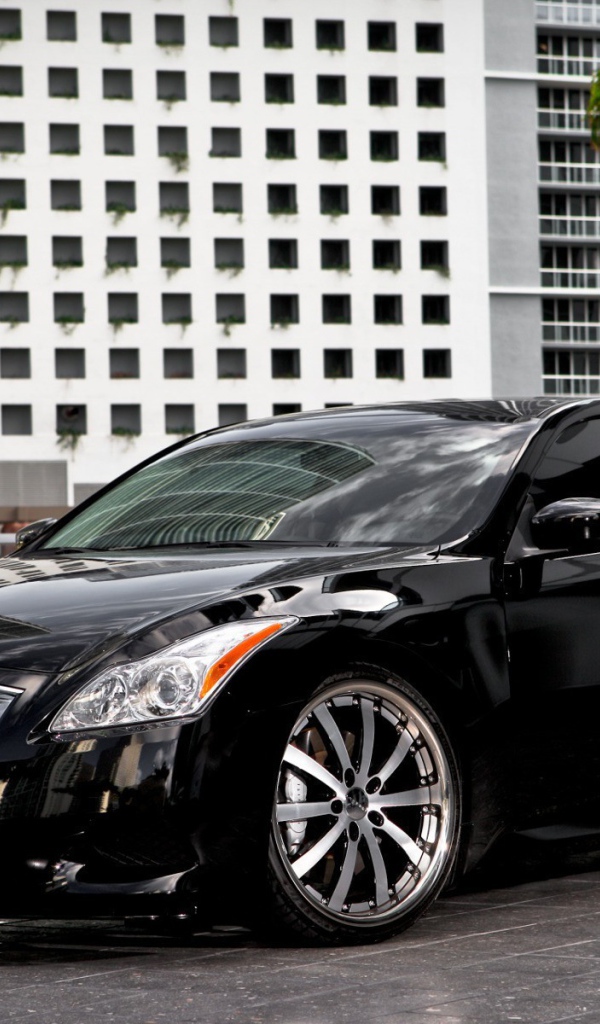 Черный Infiniti на фоне белого здания