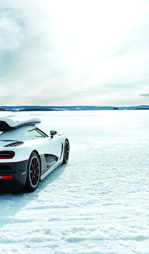 Белый Koenigsegg на заснеженном поле