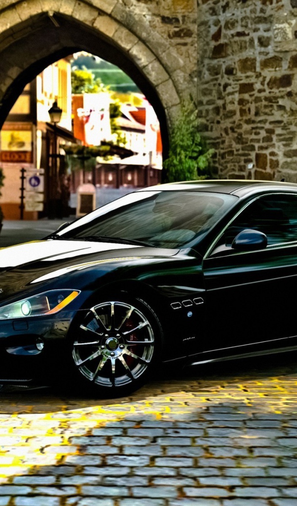 Черный Maserati gran turismo у каменной арки