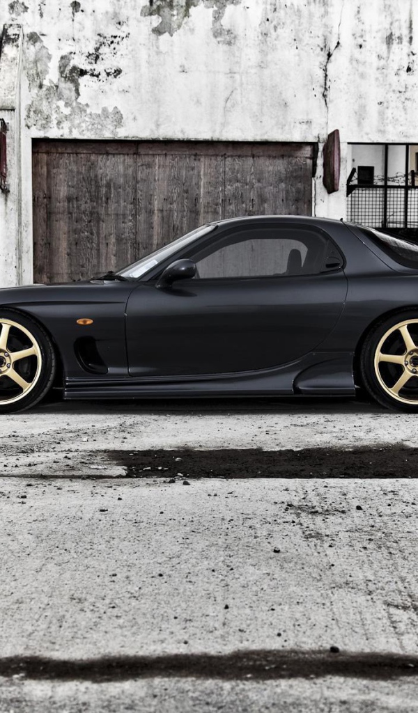 Черная Mazda RX-7 на сером бетоне