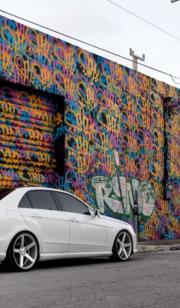 Белый Mercedes-Benz у раскрашенного гаража