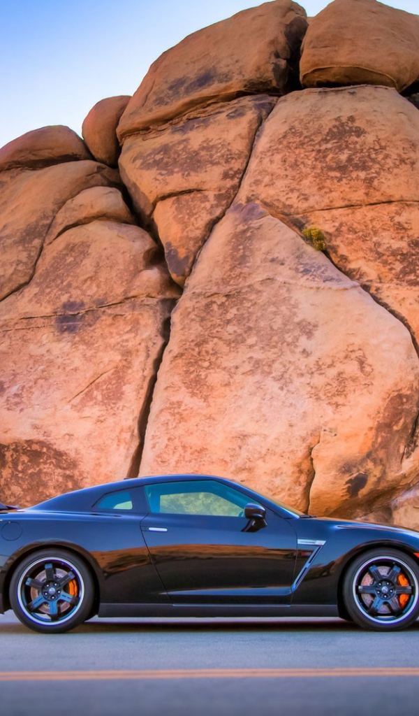 Черный Nissan GT-R у подножия скалы
