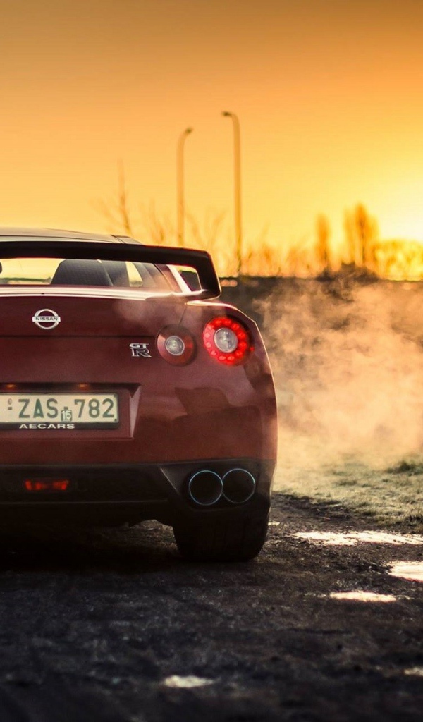 Красный Nissan у реки на рассвете