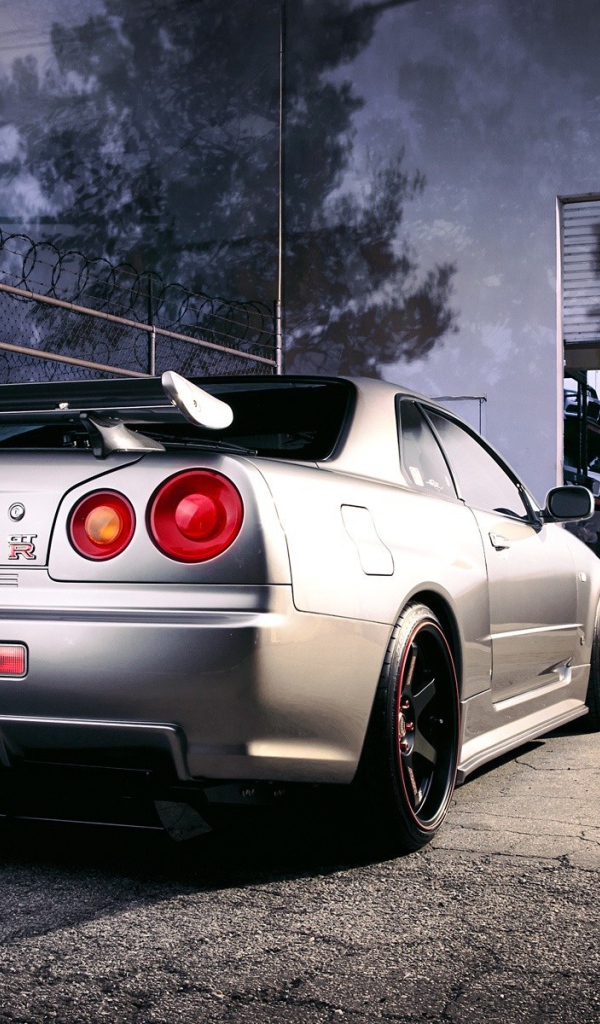 Серебристый Ниссан перед воротами