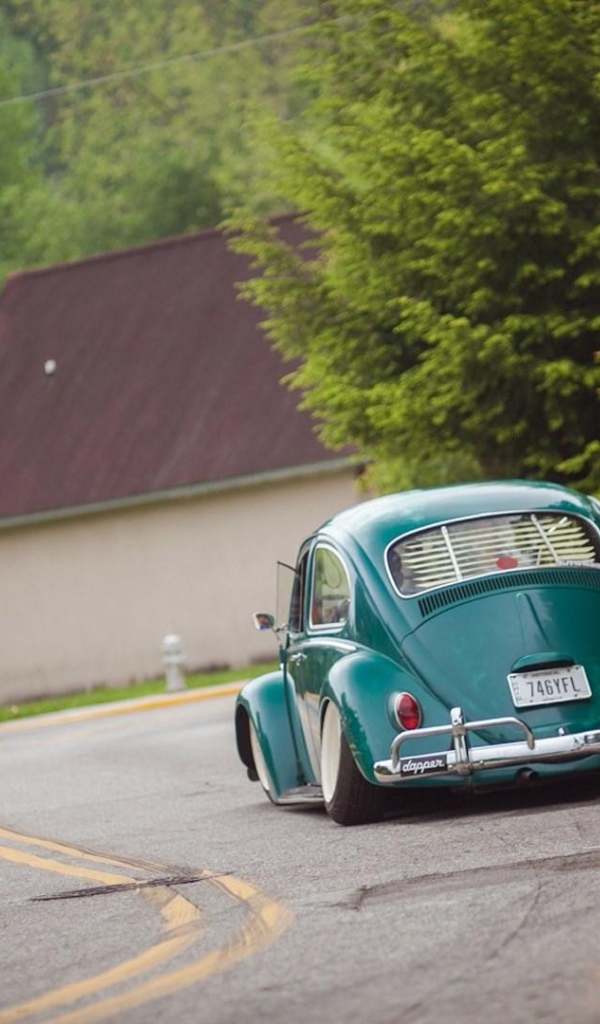 Зеленый Volkswagen Beetle на дороге