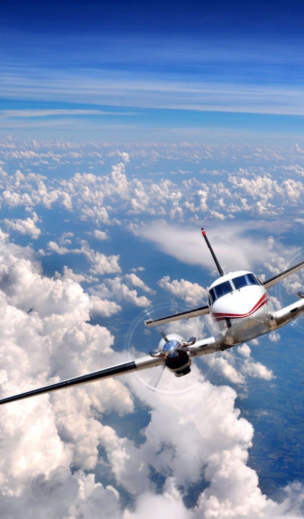 Частный самолет летит над облаками