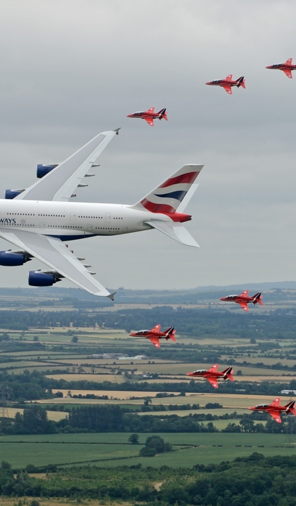 Airbus A380 в сопровождении красных истребителей