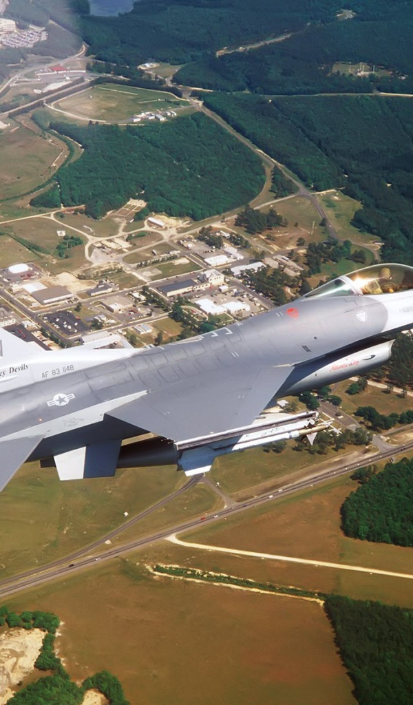 Истребитель F-16 выполняет маневр над землей