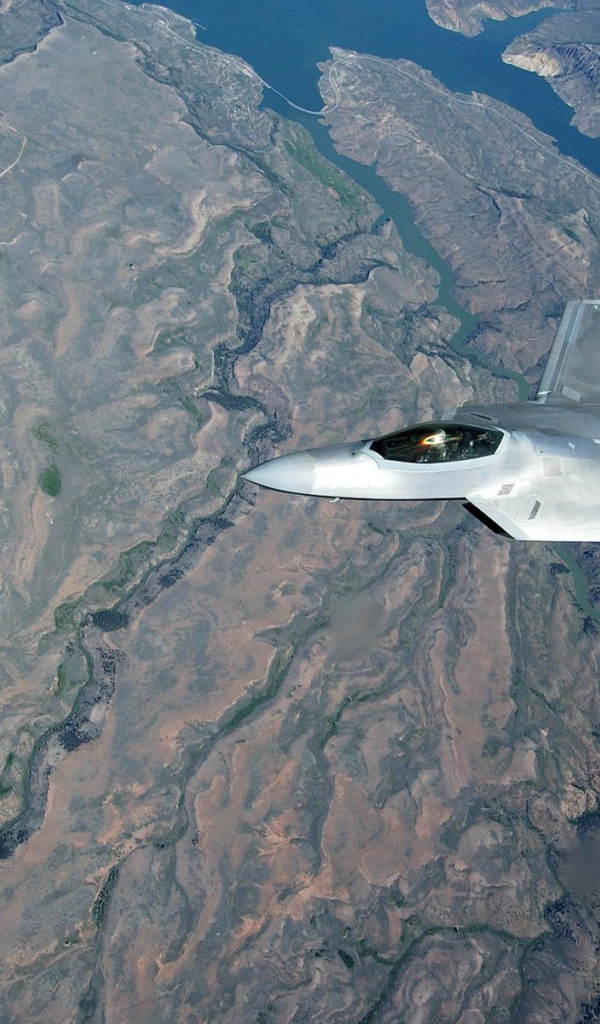 Самолет F-22 Raptor над поверхностью земли