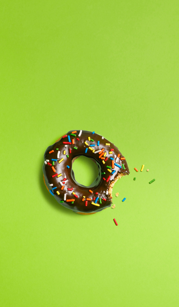 Шоколадный пончик на зеленом фоне