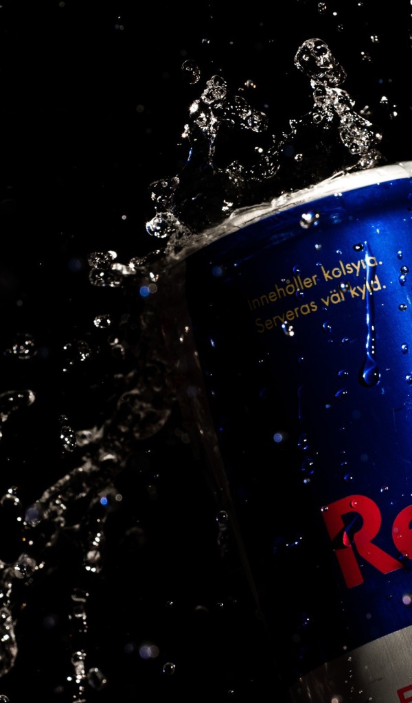Напиток Red Bull в каплях воды