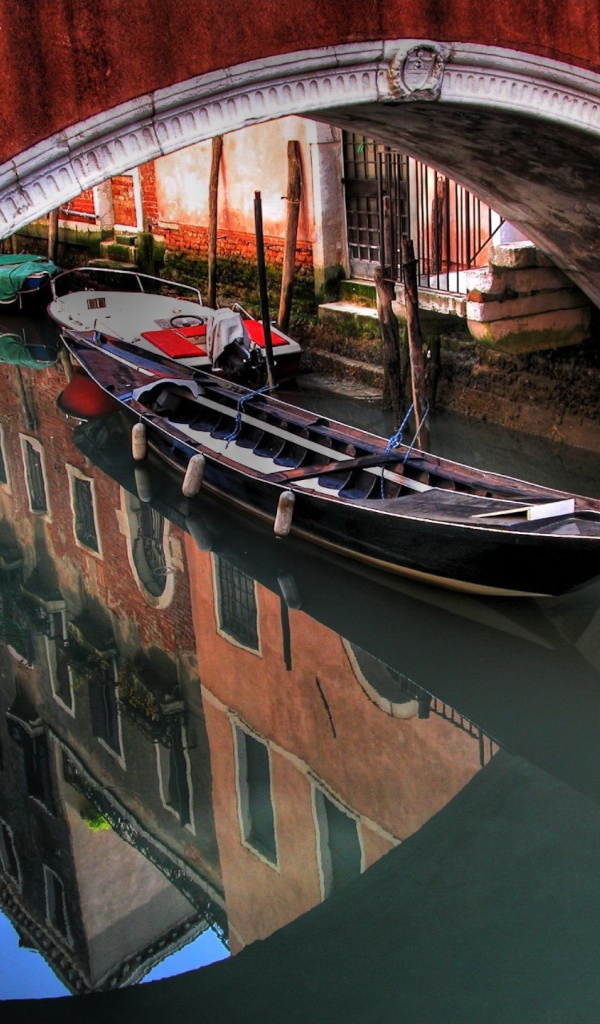 Лодка под красным мостом в Венеции