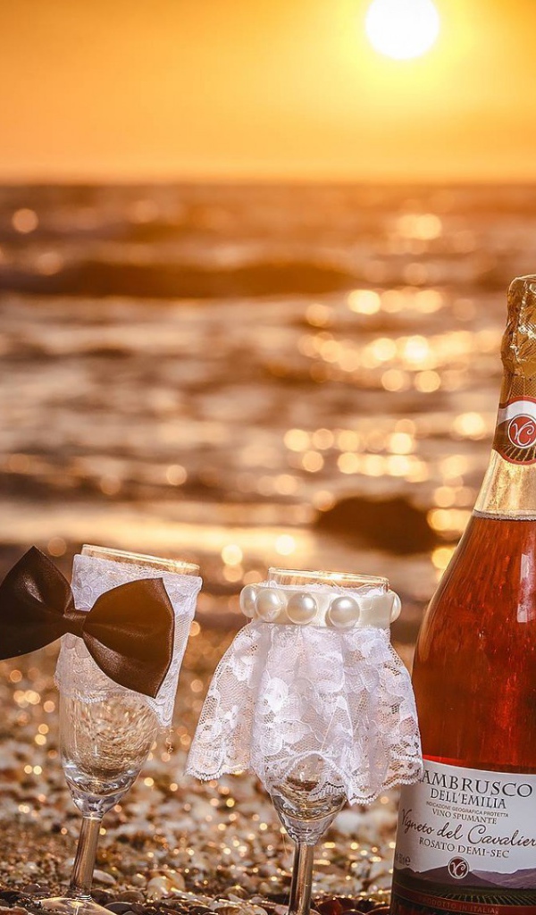 Бутылка вина и два бокала на пляже