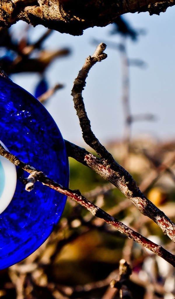 Оберег из синего стекла на дереве