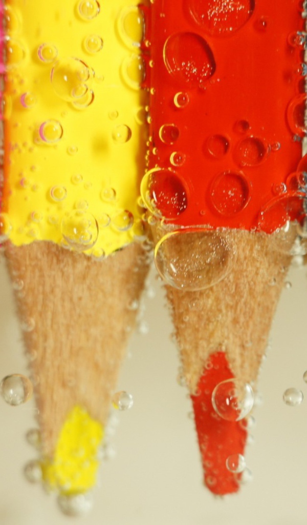 Карандаши в воде среди пузырей воздуха